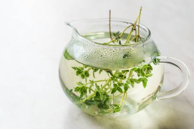 Cam çaydanlık yaprakları ile dumanı tüten bitkisel çay 