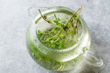 Cam çaydanlık yaprakları ile dumanı tüten bitkisel çay 