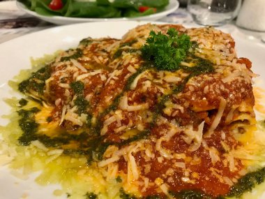 Restoranda geleneksel kıyılmış et lazanya Bolognese ve Pesto sos ile servis. 