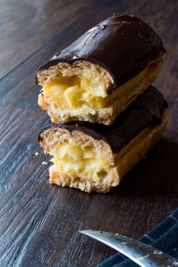 Koyu ahşap yüzeyde krema dolgulu çikolata eklerleri ikiye ayırmak.