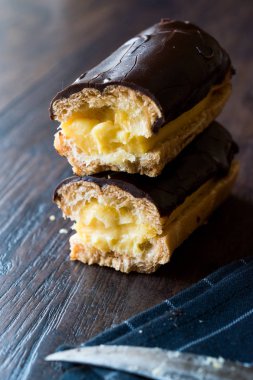 Koyu ahşap yüzeyde krema dolgulu çikolata eklerleri ikiye ayırmak.