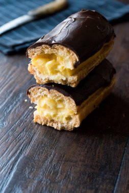 Koyu ahşap yüzeyde krema dolgulu çikolata eklerleri ikiye ayırmak.