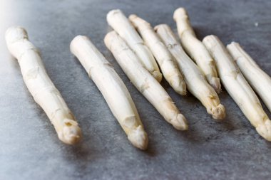 Organik çiğ beyaz kuşkonmaz mavi yüzeyi.