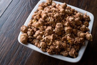 Koyu ahşap yüzey üzerinde çikolata patlamış mısır.