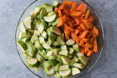 Doğranmış kabak ve havuç dilimleri cam kase.