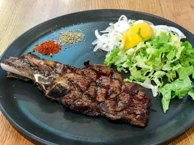 Siyah plaka büyük dana pirzola biftek salata ile servis