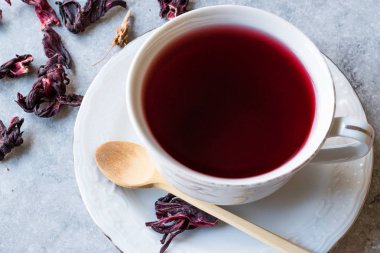 Beyaz Kupası'nda kırmızı sıcak ebegümeci çayı ile kurutulmuş Hibiscus çay yaprakları