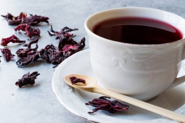 Beyaz Kupası'nda kırmızı sıcak ebegümeci çayı ile kurutulmuş Hibiscus çay yaprakları