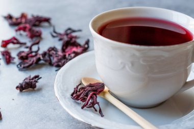 Beyaz Kupası'nda kırmızı sıcak ebegümeci çayı ile kurutulmuş Hibiscus çay yaprakları