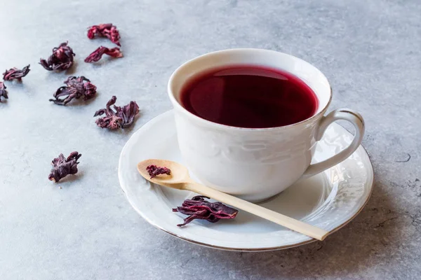 Red Hot Hibiscus Tea in White Cup with Dried Hibiscus Tea Leaves
