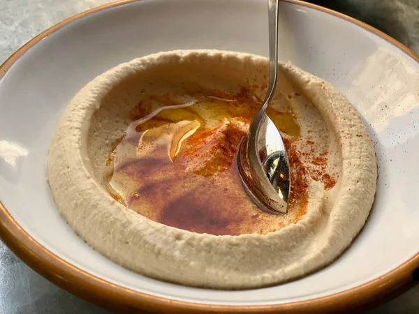 Hummus / húmus clássico com molho de manteiga frita e colher — Fotografia de Stock