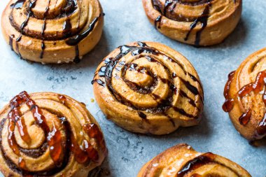 Taze pişmiş rulo tarçın karamel ve çikolata sos ile.