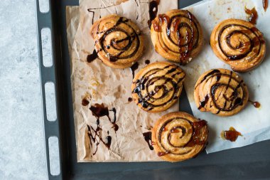 Taze pişmiş rulo tarçın karamel ve çikolata sos ile.