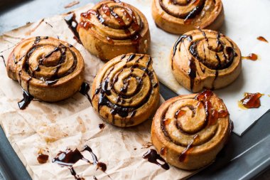 Taze pişmiş rulo tarçın karamel ve çikolata sos ile.