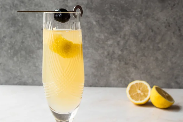 French 75 Champagner-Cocktail mit Zitronenschale und schwarzer Olive — Stockfoto