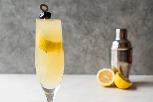 French 75 Champagner-Cocktail mit Zitronenschale und schwarzer Olive — Stockfoto