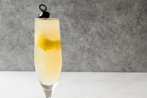 French 75 Champagner-Cocktail mit Zitronenschale und schwarzer Olive — Stockfoto