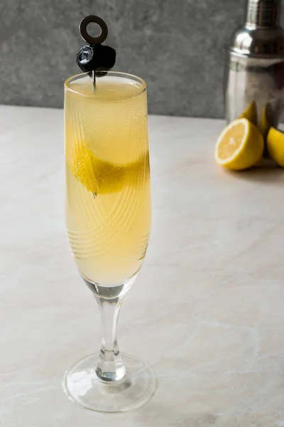 French 75 Champagne Cocktail con buccia di limone e olive nere — Foto Stock