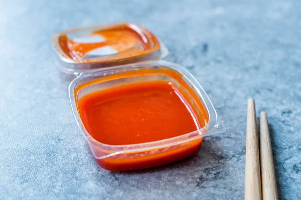 Hot Spicy Red Sriracha Sauce in Plastic Box / Package or Container for Fast Food Ready to Eat Традиційний харчовий соус. — стокове фото