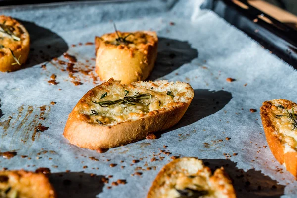 Garlic Parmesan Cheese Bread Slices on Baking Paper Sheet with Oven Tray.
