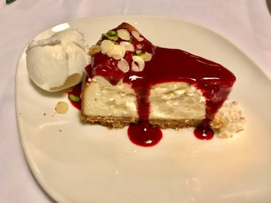 İtalyan restoranında ahududu soslu, dondurmalı, fıstıklı ve fıstıklı cheesecake servis ediliyor. Geleneksel Tatlı.