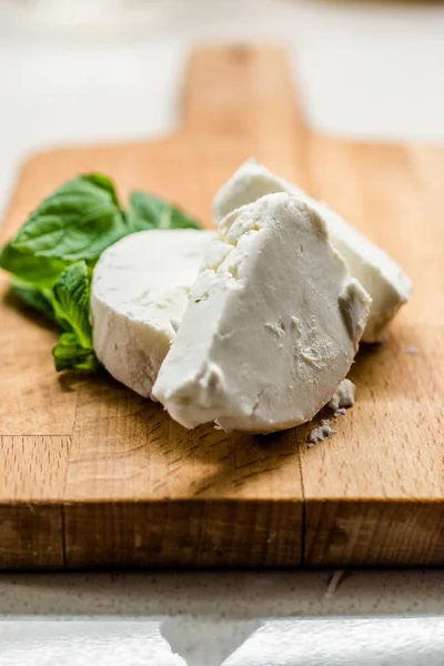 Rebanadas de queso de cabra en tablero de madera. Listo para comer . — Foto de Stock