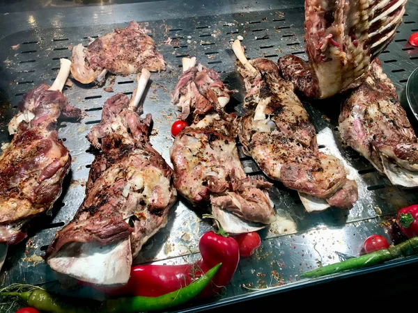 Muslo de cordero picante a la parrilla con especias en el escaparate del restaurante de carne local en venta . —  Fotos de Stock