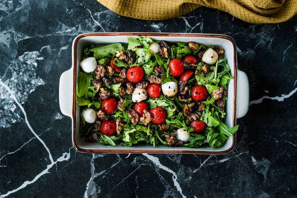 Domácí salát Arugula Rucola / Rocket Leaves se sýrovými koulemi, ořechy, černými kmínovými semínky a třešňovými rajčaty. Organické čerstvé potraviny. — Stock fotografie