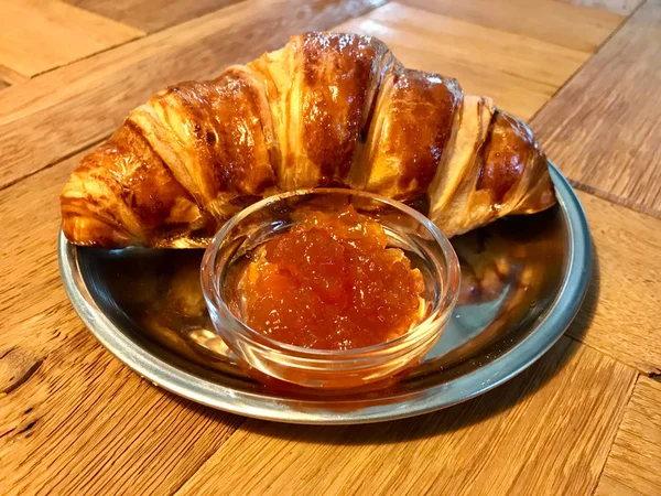 Croissant z dżemem / marmoladą w srebrnej tablicy na drewnianym stole w Cafe Shop na śniadanie. Gotowość do serwowania i jedzenia. — Zdjęcie stockowe