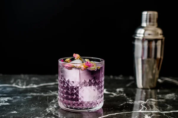 Rózsaszín Gin Tonic Koktél szárított rózsa rügyek és jég üveg kupa. — Stock Fotó