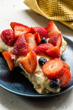 Çilekli tart dilimi ve içi çilek dolu tabaklar..