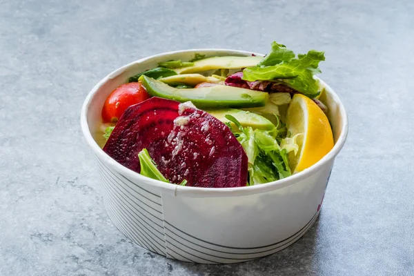 Healthy Fast Food Take Away Salad with Avocado, Beet Slice, Lettuce, Cherry Tomatoes and Sauce in Plastic Box / Package or Container. Organic Fresh Food.