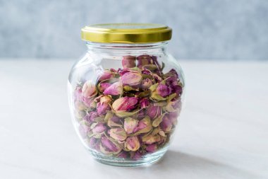 Cam kavanozda kurumuş pembe gül tozu.