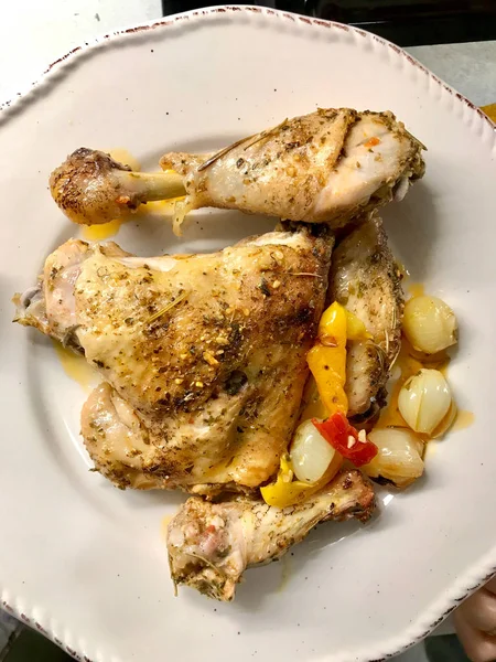 집에서 구운 건강 한 닭고기 다리에 향신료를 바르고, 양파와 마늘을 접시에 담아 먹는다. 유기농 식품. — 스톡 사진