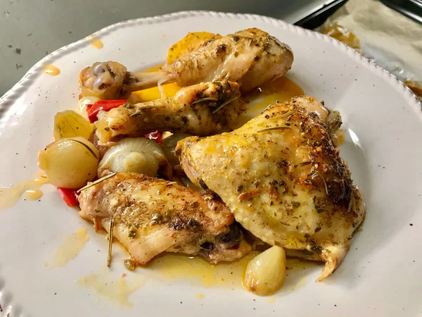 집에서 구운 건강 한 닭고기 다리에 향신료를 바르고, 양파와 마늘을 접시에 담아 먹는다. 유기농 식품. — 스톡 사진