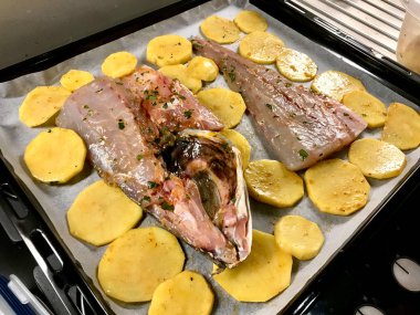 Sciaena Umbra Çiğ Balık Fileto Patates Dilimleri ile Fırın / Pişirmeye Hazır Kağıt Çarşaf. Organik Deniz Ürünleri.