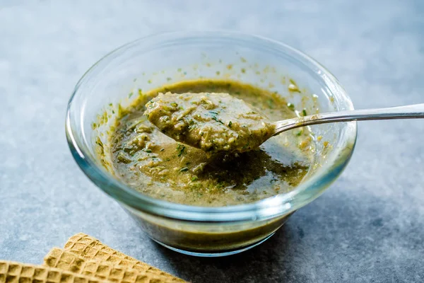 Salsa de ensalada de hierbas verde casera con raíces de plantas en cuenco de vidrio con cuchara. Alimentos orgánicos caseros . —  Fotos de Stock