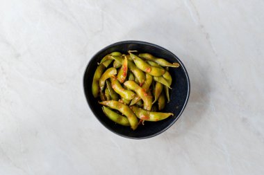 Baharatlı Sambal Edamame ile Chopsticks / Baharatlı Stil ile Red Hot Chili Suce. Geleneksel Organik Gıda.
