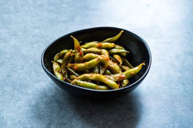 Baharatlı Sambal Edamame ile Chopsticks / Baharatlı Stil ile Red Hot Chili Suce. Geleneksel Organik Gıda.