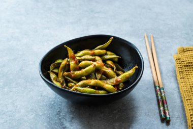 Baharatlı Sambal Edamame ile Chopsticks / Baharatlı Stil ile Red Hot Chili Suce. Geleneksel Organik Gıda.