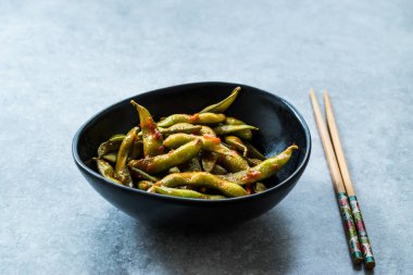 Baharatlı Sambal Edamame ile Chopsticks / Baharatlı Stil ile Red Hot Chili Suce. Geleneksel Organik Gıda.