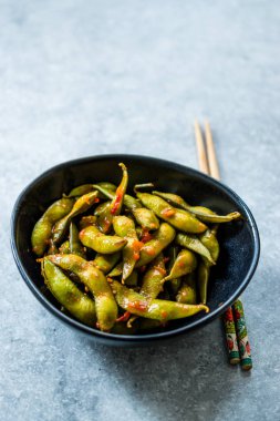 Baharatlı Sambal Edamame ile Chopsticks / Baharatlı Stil ile Red Hot Chili Suce. Geleneksel Organik Gıda.