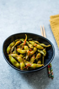 Baharatlı Sambal Edamame ile Chopsticks / Baharatlı Stil ile Red Hot Chili Suce. Geleneksel Organik Gıda.