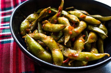 Baharatlı Sambal Edamame ile Chopsticks / Baharatlı Stil ile Red Hot Chili Suce. Geleneksel Organik Gıda.