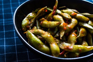 Baharatlı Sambal Edamame ile Chopsticks / Baharatlı Stil ile Red Hot Chili Suce. Geleneksel Organik Gıda.