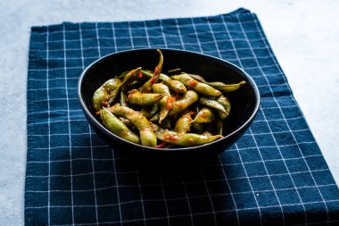 Baharatlı Sambal Edamame ile Chopsticks / Baharatlı Stil ile Red Hot Chili Suce. Geleneksel Organik Gıda.