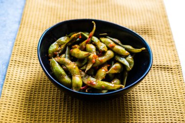 Baharatlı Sambal Edamame ile Chopsticks / Baharatlı Stil ile Red Hot Chili Suce. Geleneksel Organik Gıda.