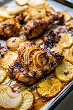 Soğan ve patatesli fırında tavuk budu. 