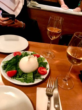 Purslane, Arugula Rucola veya Rocket Salata ve Kiraz Yapraklı Burrata Peyniri Yerel İtalyan Restoranında. 