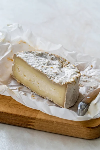 Meio queijo de brie inteiro cortado com faca na placa de madeira também chamado de Mera turca do leite de cabra . — Fotografia de Stock
